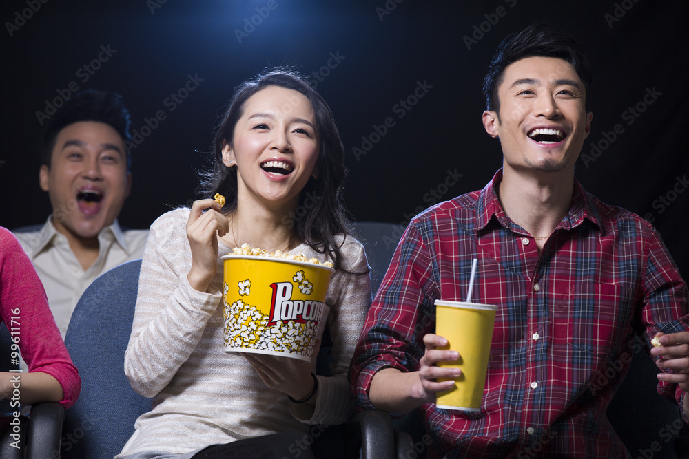 在电影院看电影的年轻夫妇