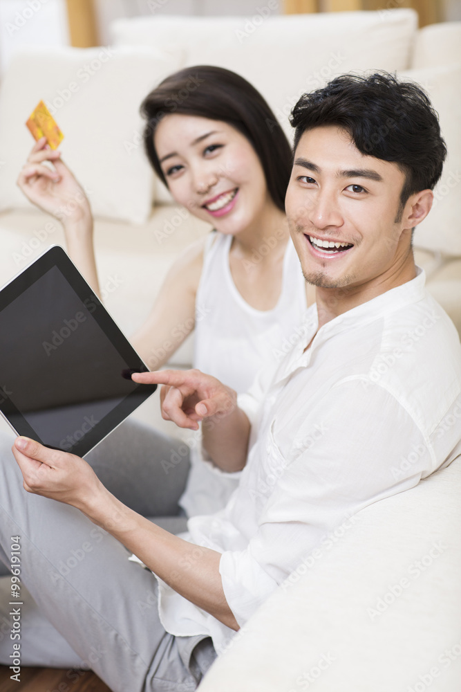 Cheerful young couple using a digital tablet shopping online 