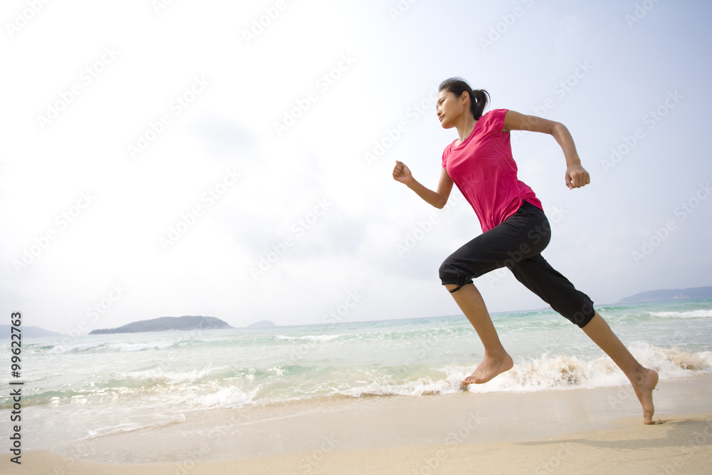 年轻女子在海滩上奔跑
