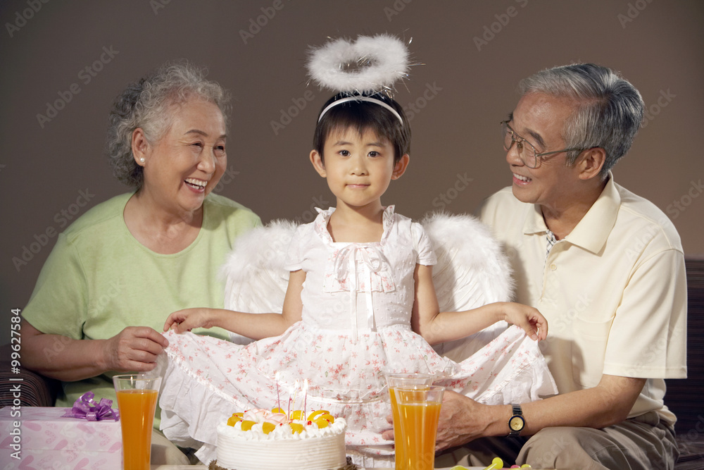 祖父母对打扮成天使的孙女微笑