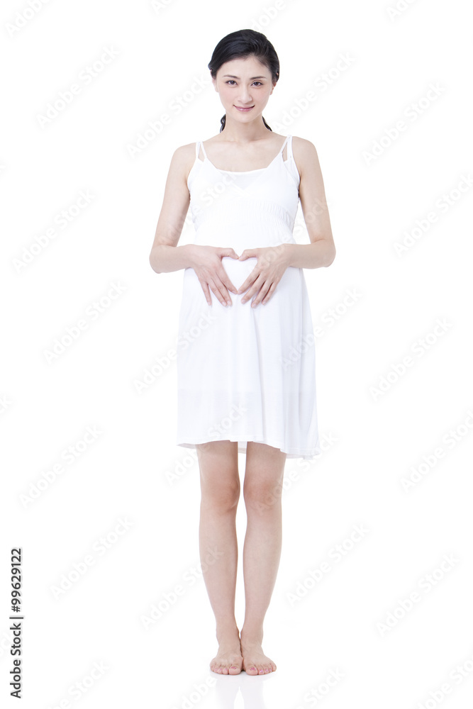 Happy pregnant woman doing heart shape hand sign
