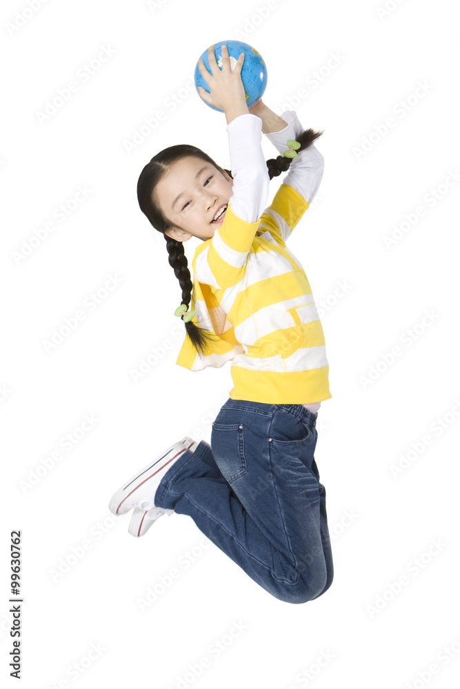 Young girl jumping with a globe