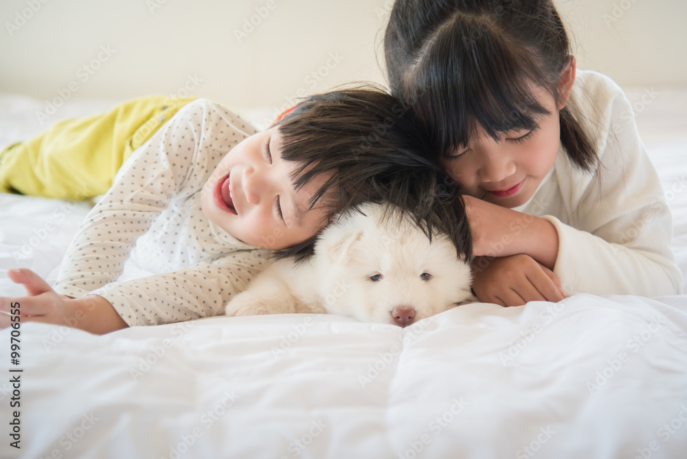 西伯利亚哈士奇与亚洲儿童躺在白色床上
