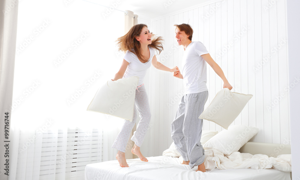 快乐的情侣在床上蹦蹦跳跳，玩得很开心