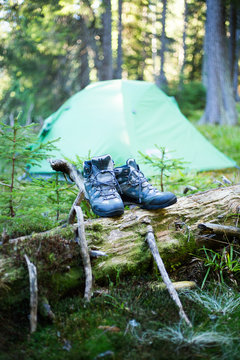 露营的人们在帐篷旁穿上登山鞋。