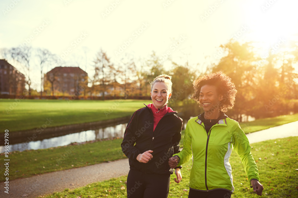 两名女运动员在阳光公园跑步