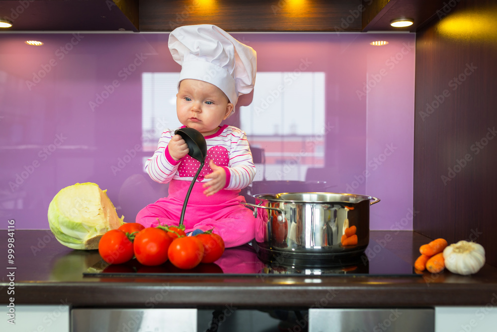 小女婴戴厨师帽在厨房做饭