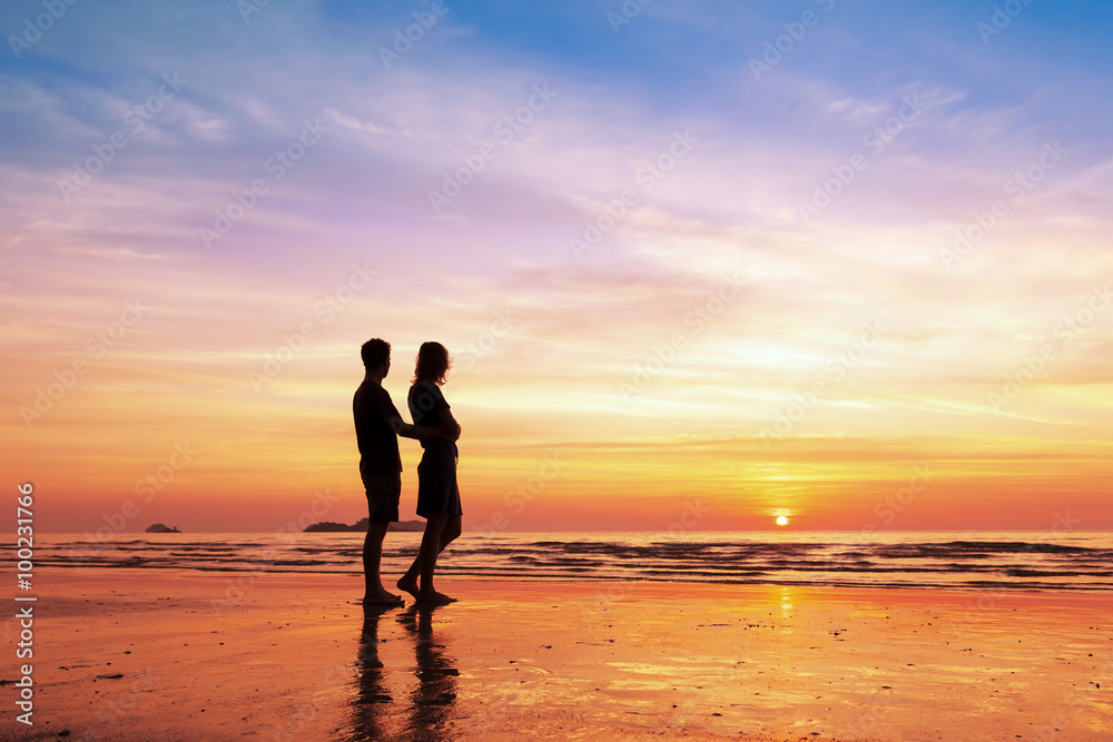 日落时分，情侣在海滩上共度浪漫时刻