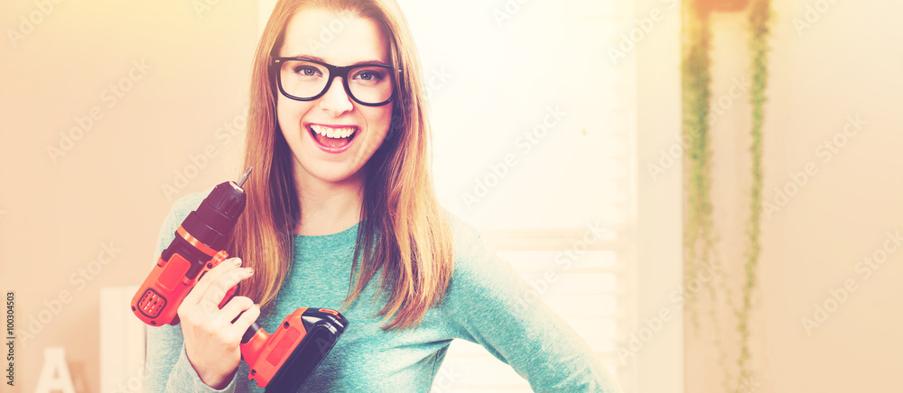 Young woman with cordless drill