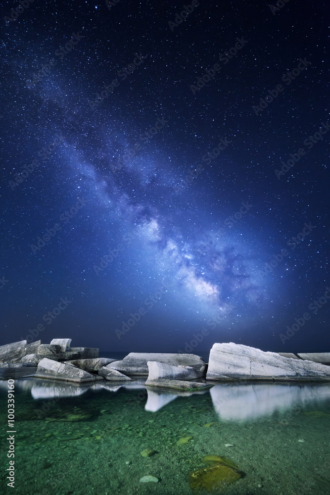 海边有石头的乳白色夜景。星空