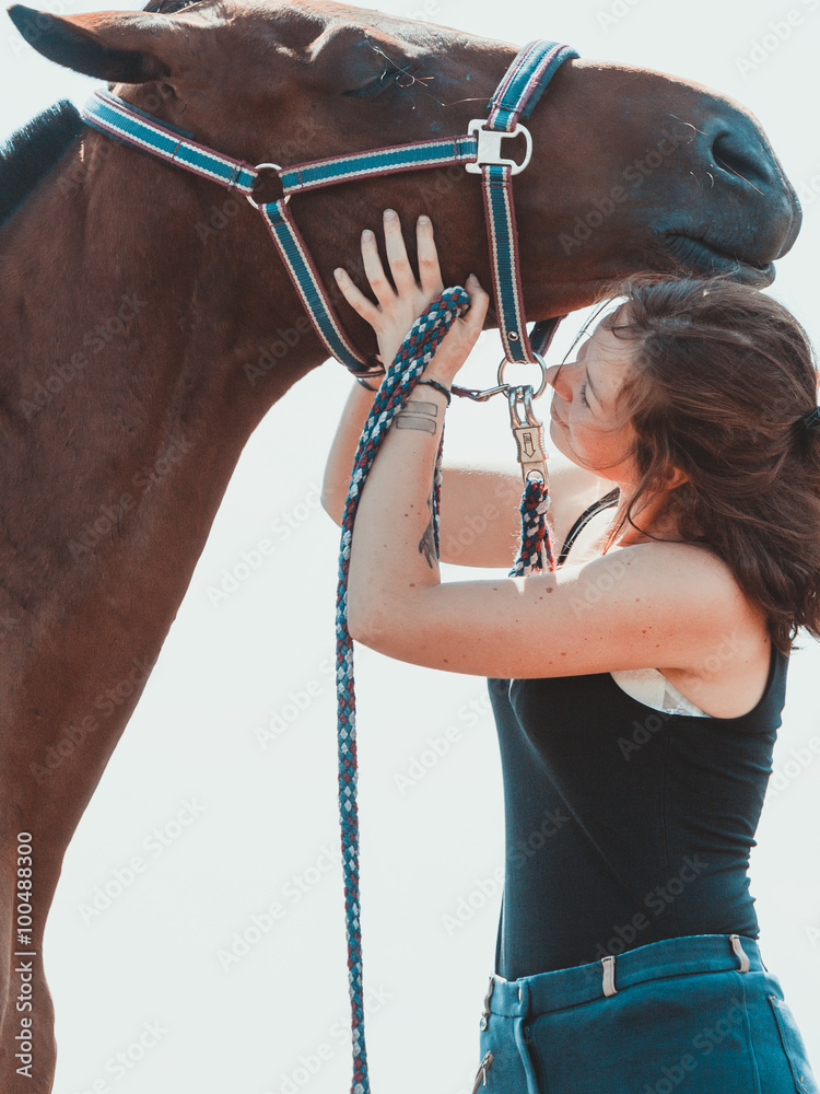 年轻的女女孩在照顾马。