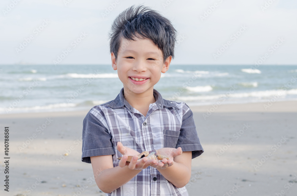 Young boy with shell on the bech