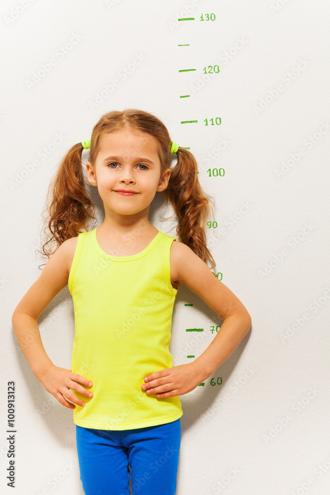 小女孩站在测量高度尺旁