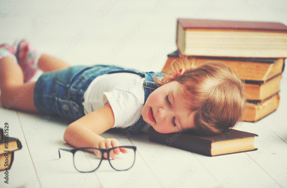 疲惫的小女孩为了书睡着了