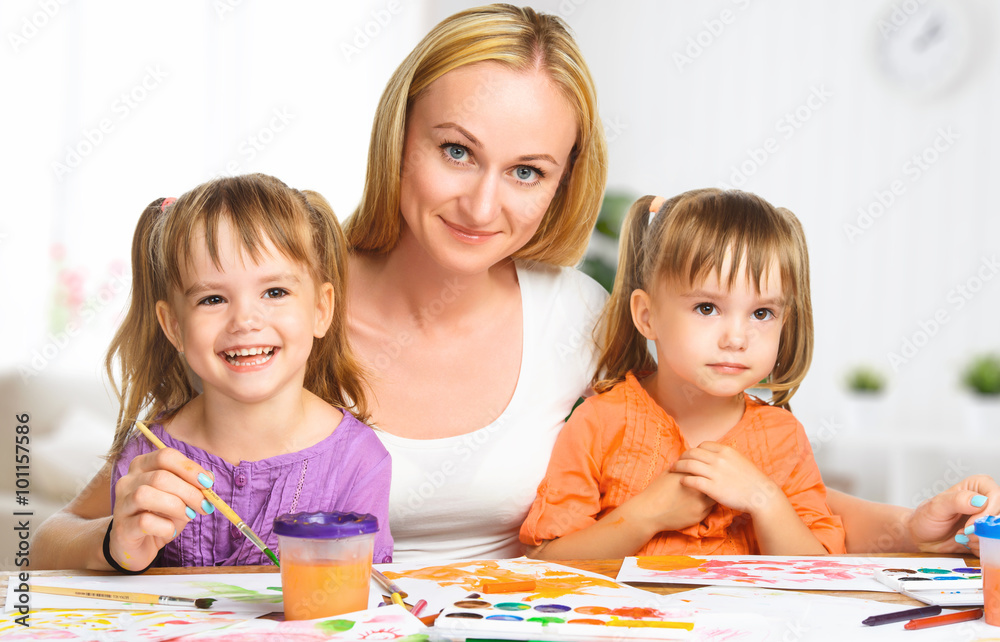 孩子双胞胎姐妹在幼儿园和妈妈一起画画