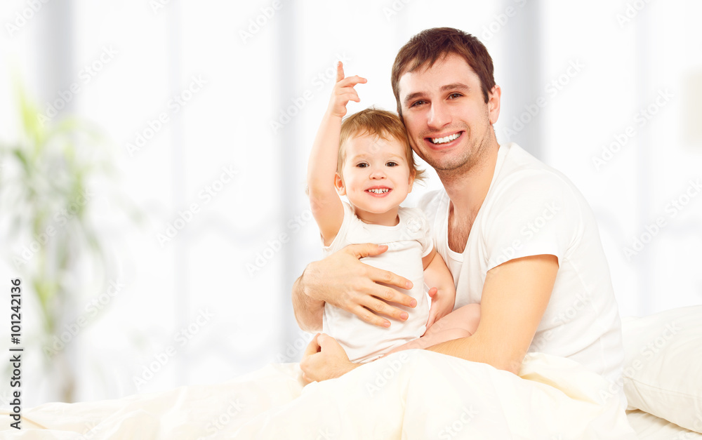 幸福的家庭父亲和孩子女儿在床上玩耍