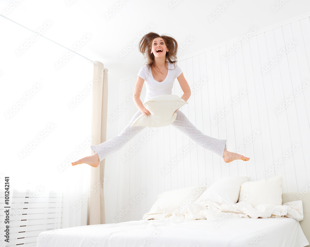 happy girl jumping and having fun in bed