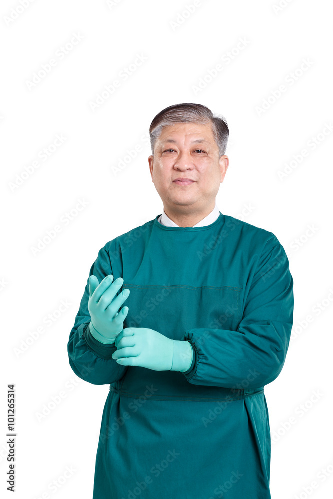 戴着手套，身穿绿色手术服的亚洲老医生