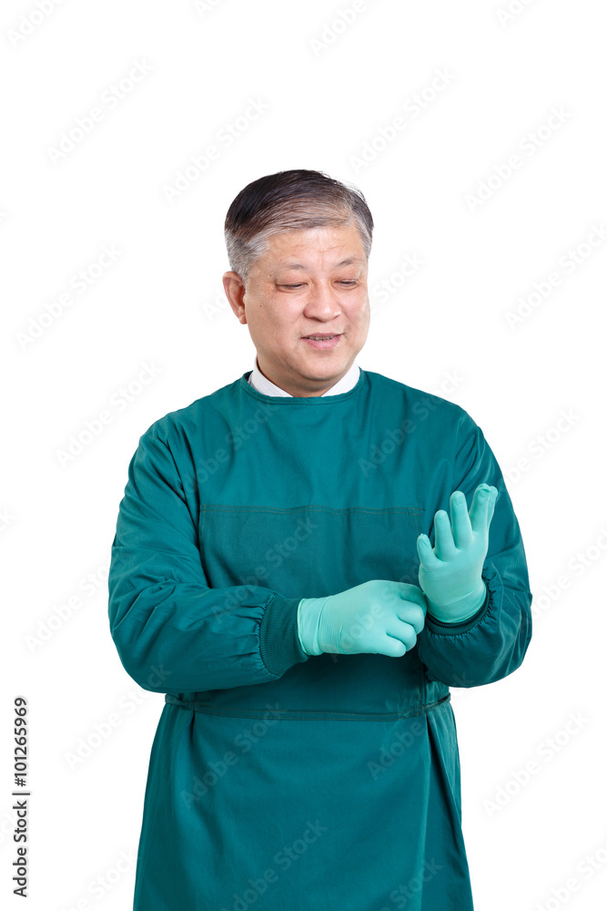 戴着手套，身穿绿色手术服的亚洲老医生