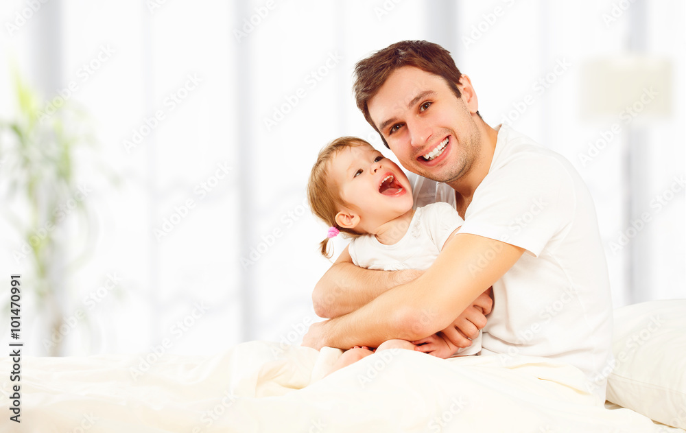 幸福的家庭父亲和孩子女儿在床上玩耍