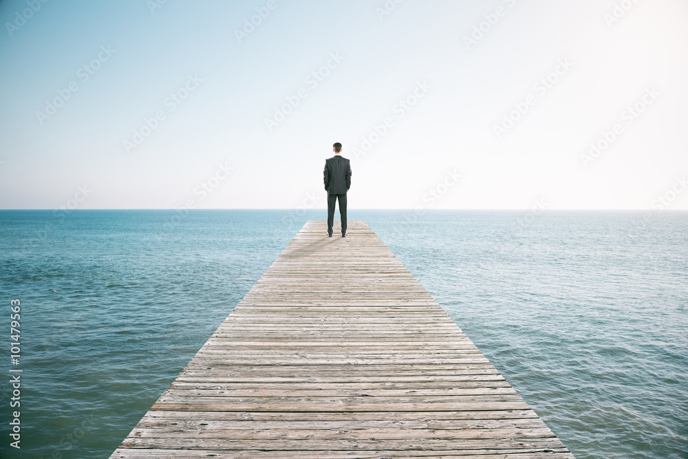 一名男子站在码头上，眺望着码头的远处
