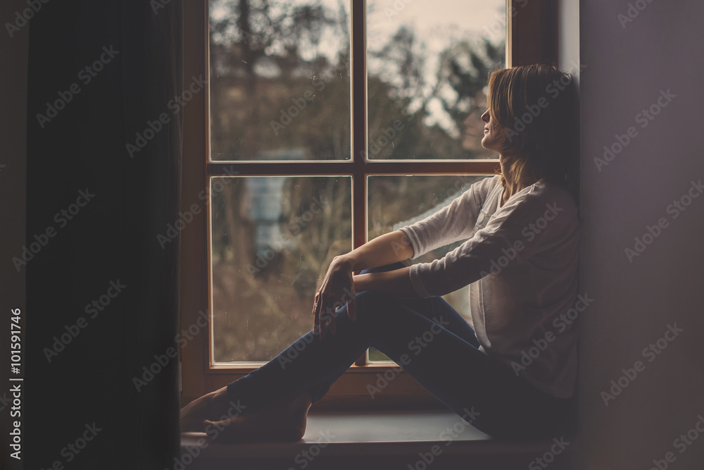 年轻漂亮的女人，坐在窗户上，向外看