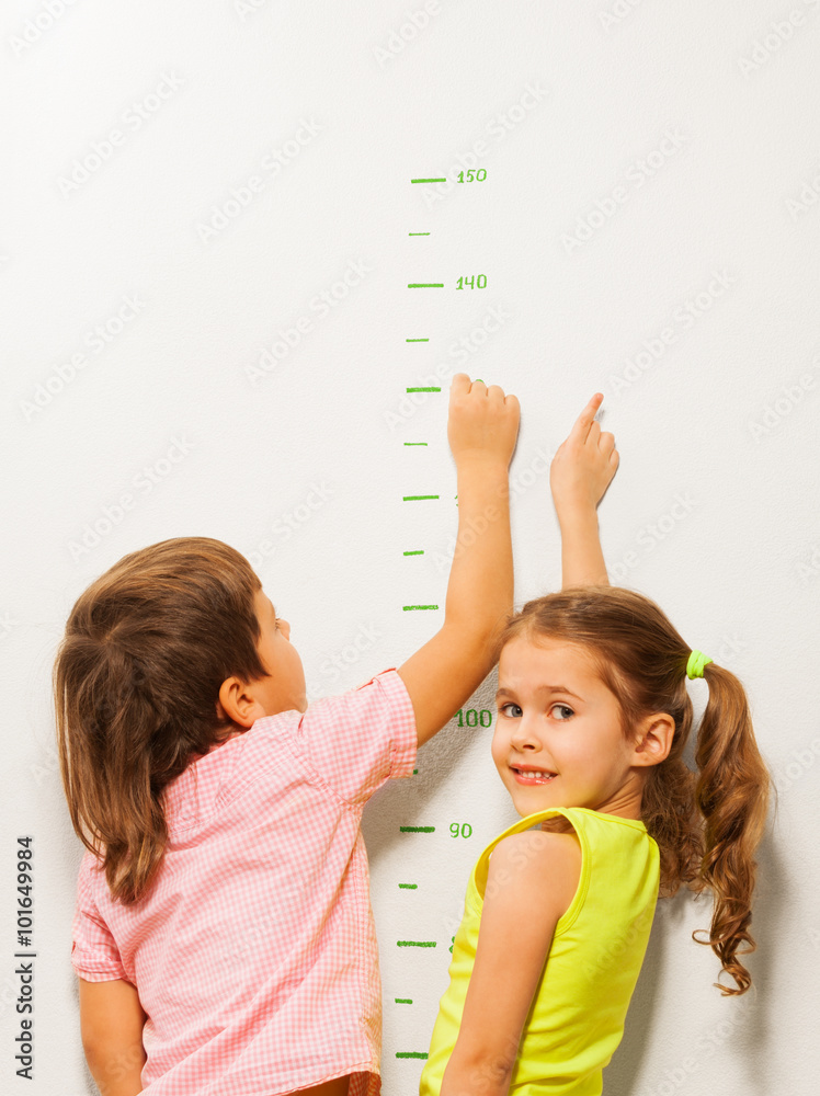 两个孩子在家墙上阅读高度