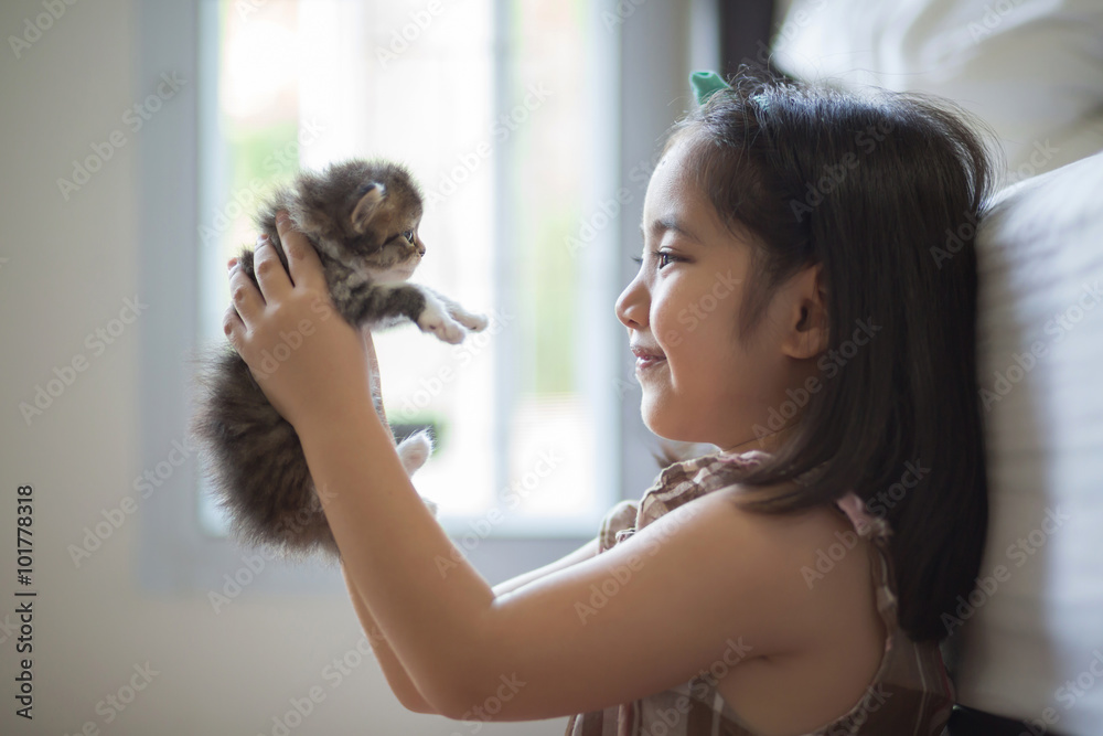 可爱的亚洲小女孩亲吻她的小猫