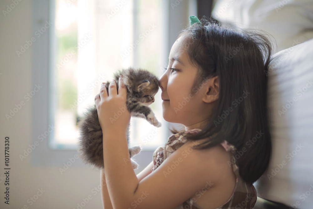 可爱的亚洲小女孩亲吻她的小猫