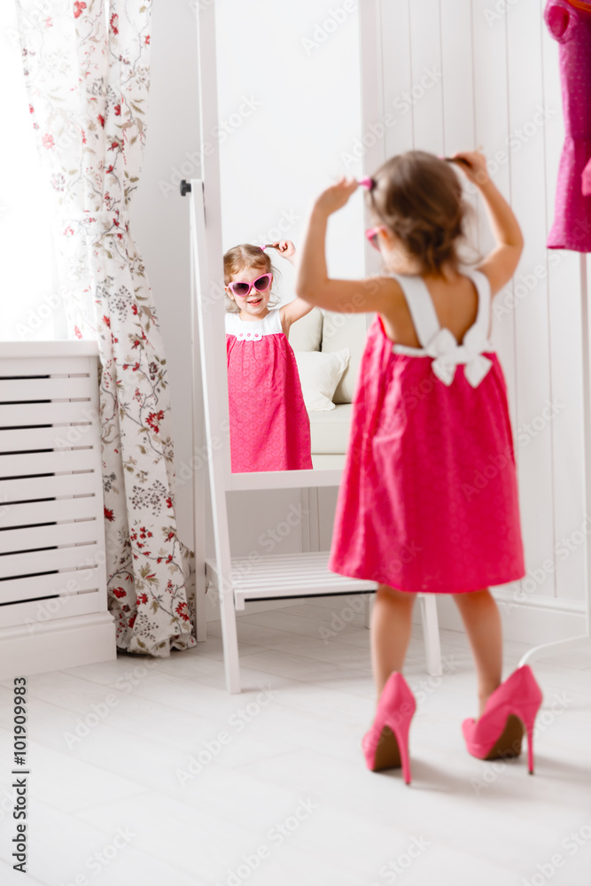 little girl child fashionista looking in the mirror at home