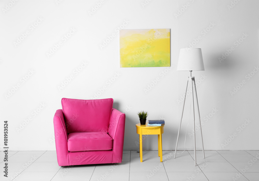 客厅内部，白色墙壁背景上有粉色扶手椅、灯和黄色椅子
