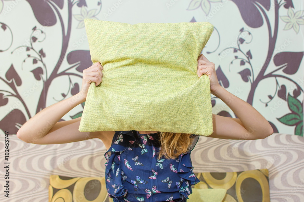 girl hiding behind a pillow