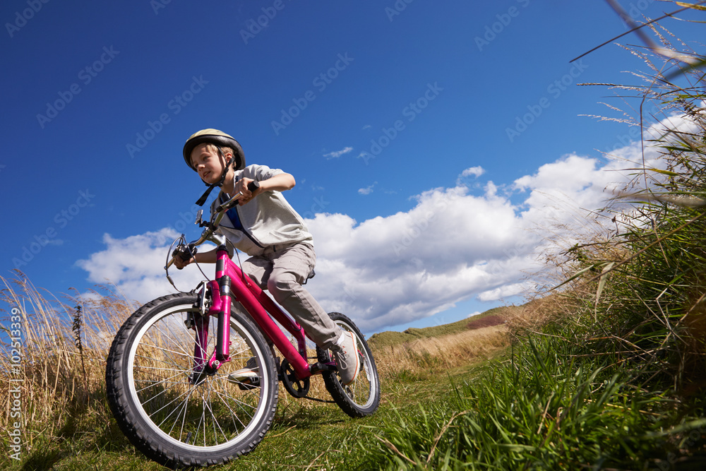 骑自行车穿越乡村的男孩低角度拍摄