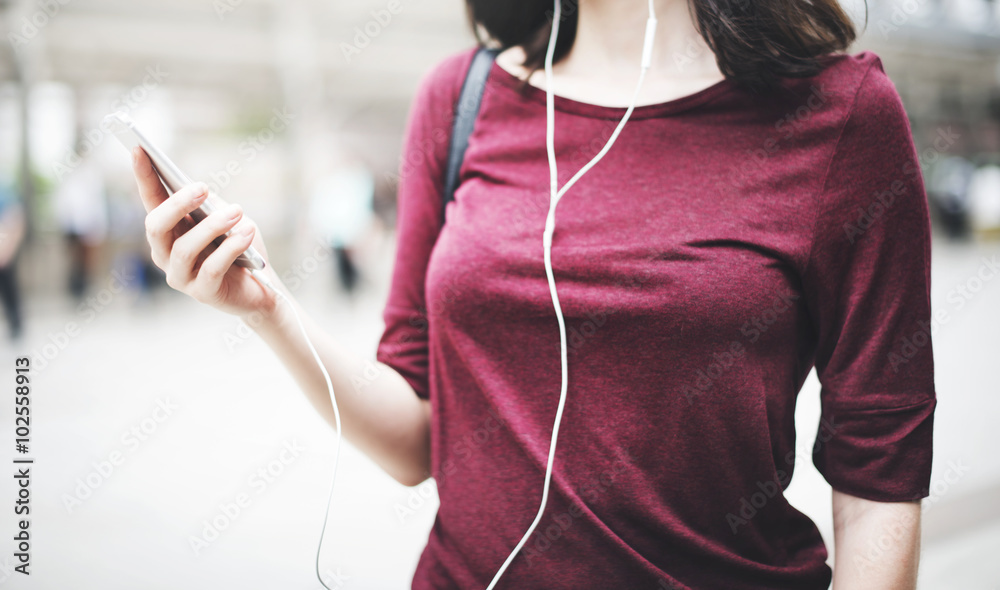 女性聆听音乐媒体娱乐行走概念