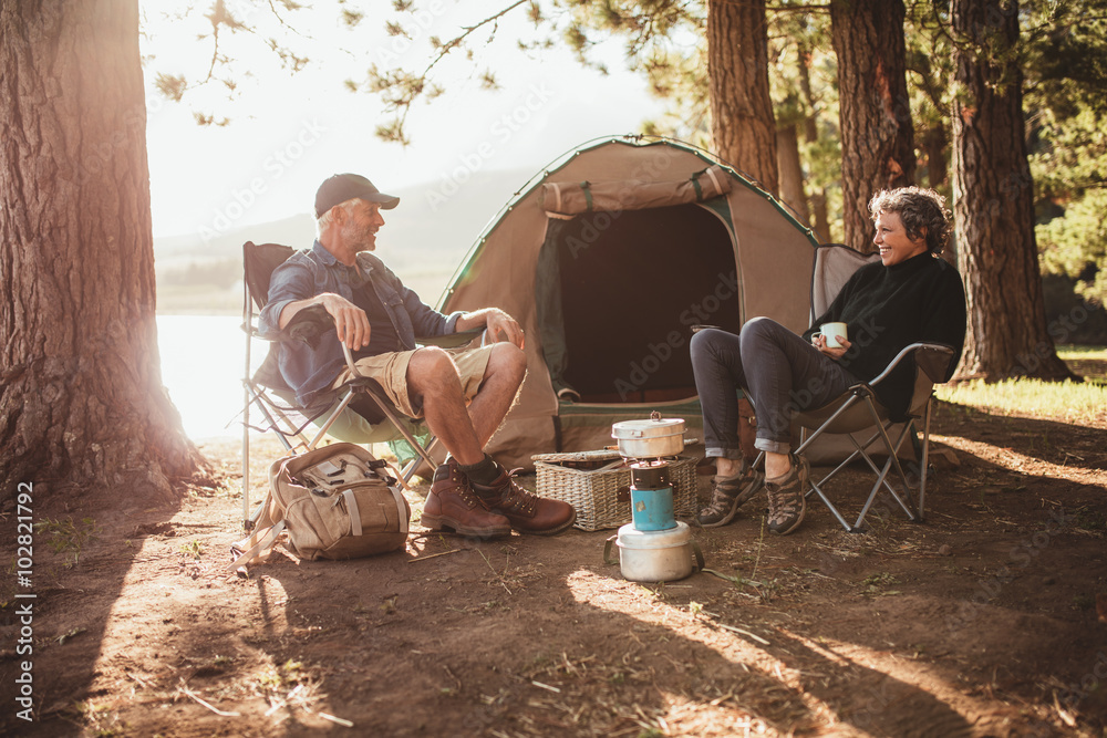 情侣在露营地帐篷旁的椅子上放松