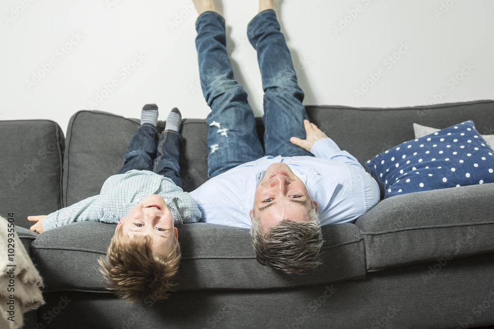父亲和儿子倒过来躺在沙发上