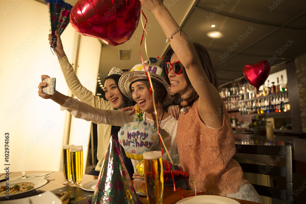 Three women are celebrating a birthday at the bar