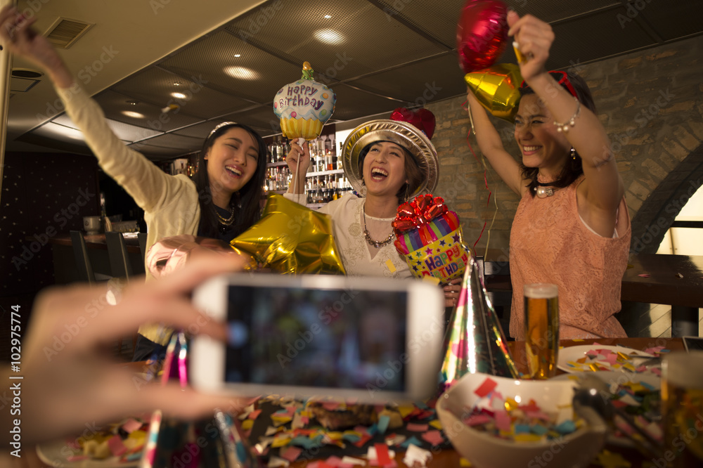 三个女人在生日派对上拿着气球兴高采烈
