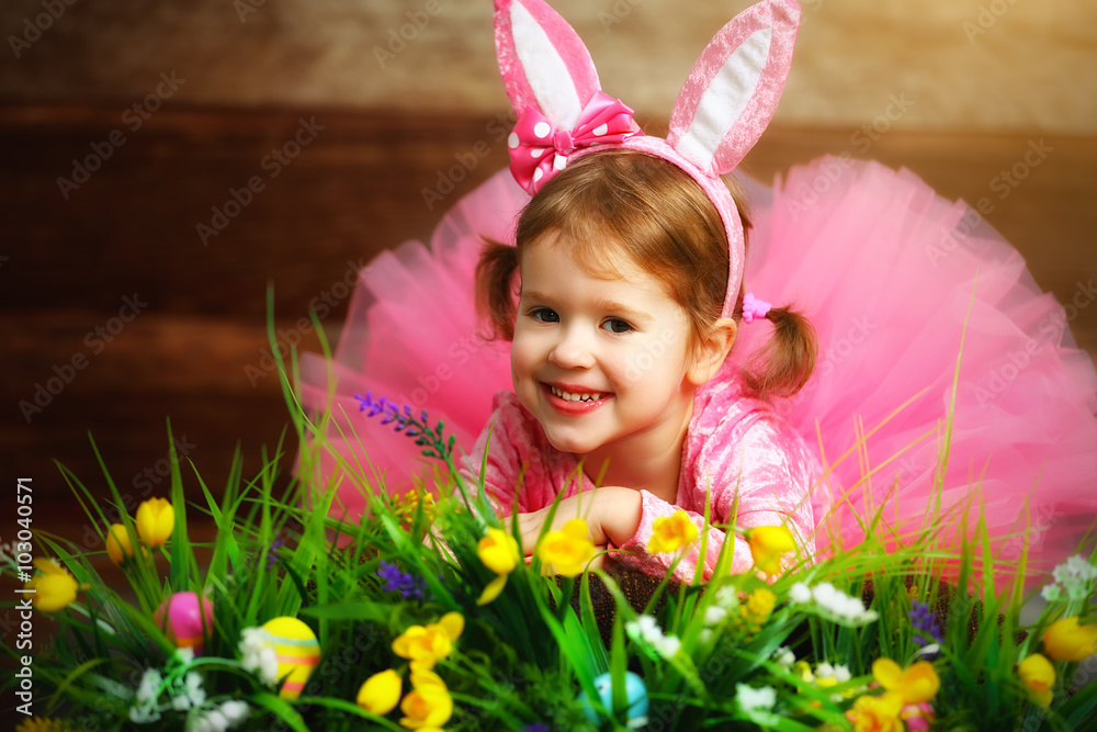 穿着戏服的快乐小女孩草地和草地上的复活节兔子