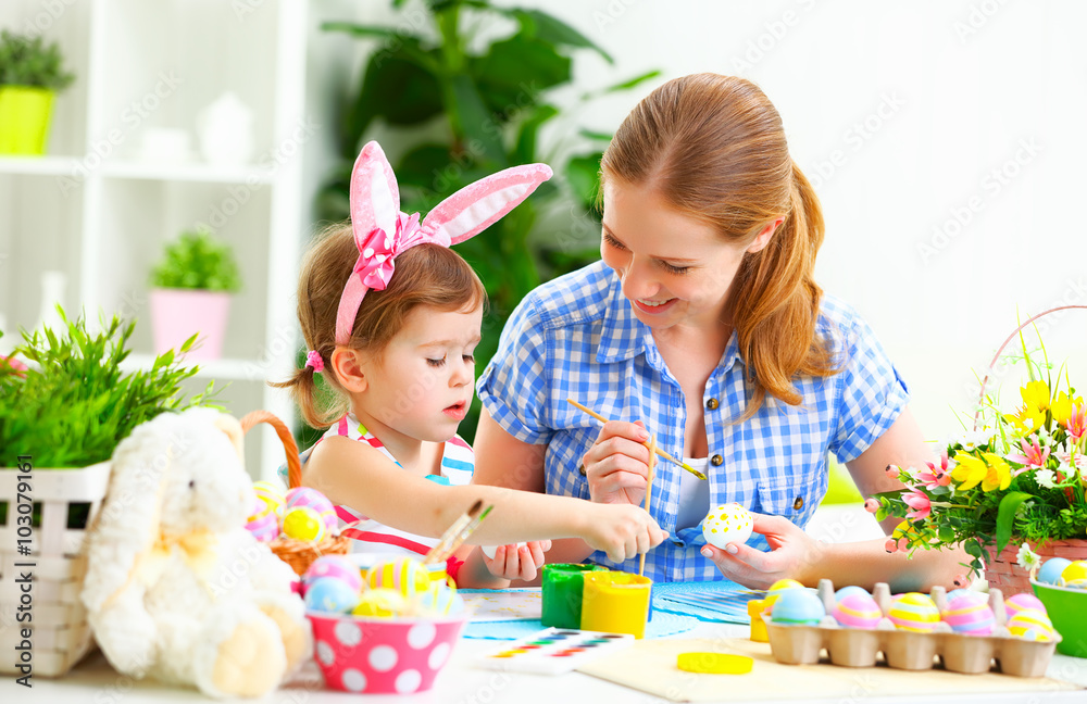 快乐家庭母亲和小女孩为复活节画彩蛋