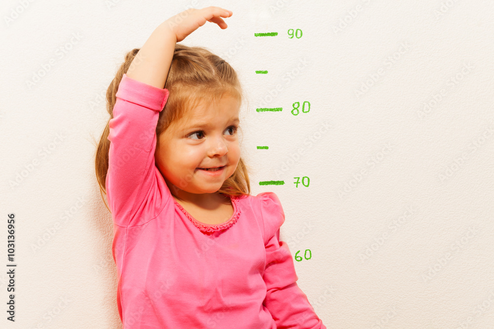小女孩在墙上测量身高
