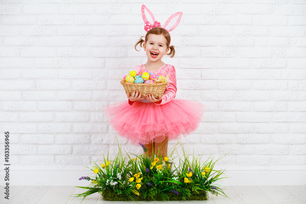 穿着戏服的快乐孩子带着鸡蛋和绿草的复活节兔子