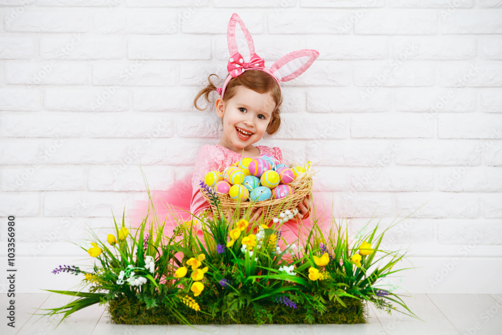 Happy chil in costume Easter bunny with eggs and green grass wit