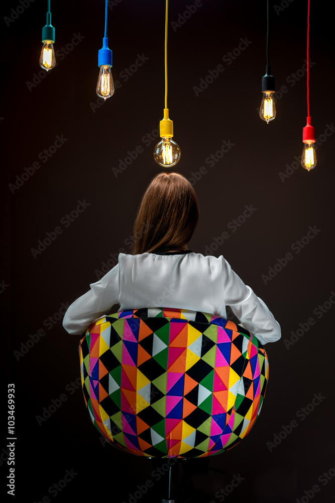 坐在椅子上的女人，手里拿着五颜六色的灯