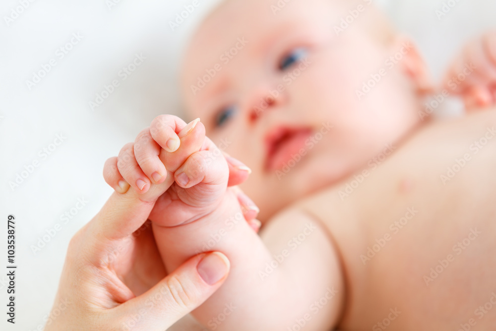 父母爱的概念。婴儿牵着母亲的手指