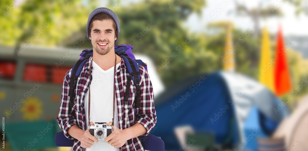 Composite image of portrait of happy man holding camera