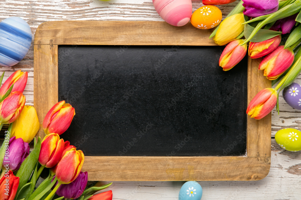 Easter eggs and tulips with blackboard