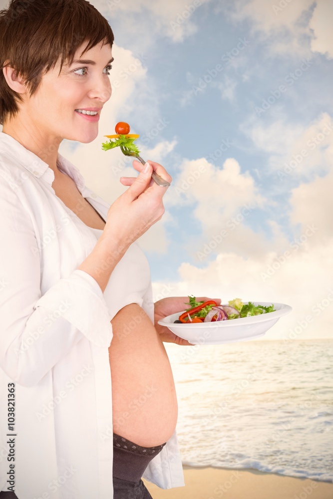 微笑的孕妇吃沙拉的合成图像