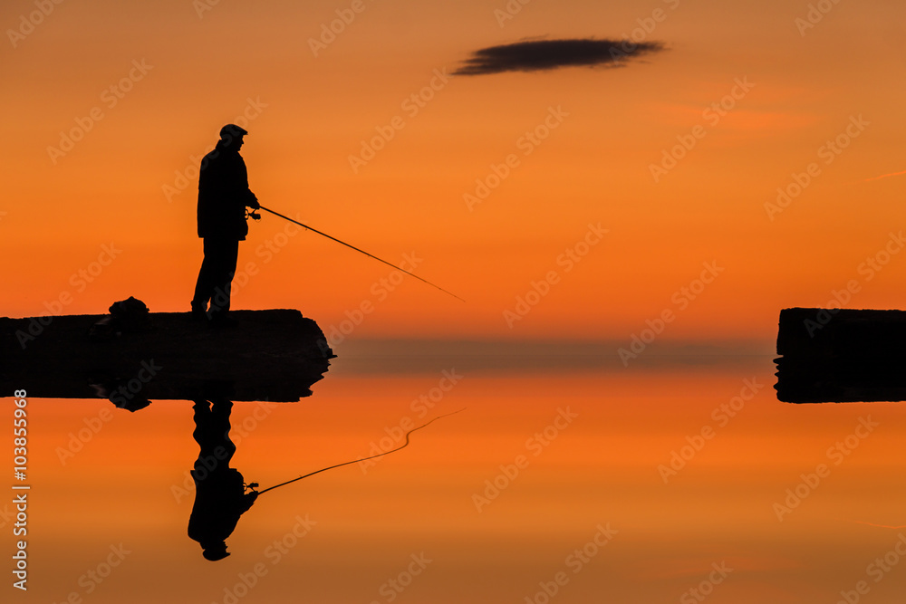 水中渔夫的倒影。s在码头上钓鱼