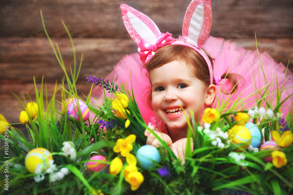 穿着戏服的快乐小女孩草地和草地上的复活节兔子